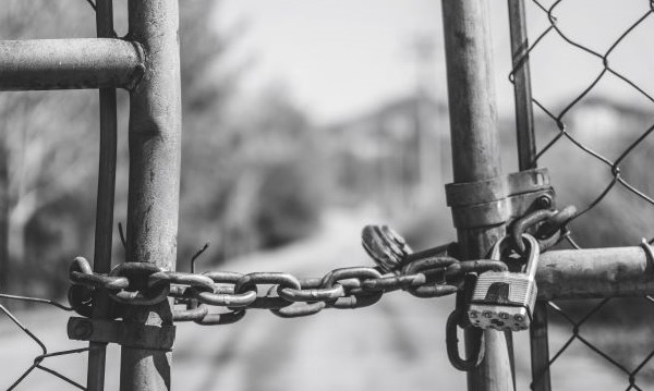 Border fence locked by a chain in black and white