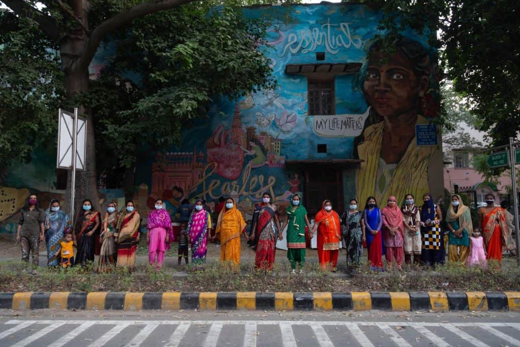 The Fearless Collective standing in front of their mural.